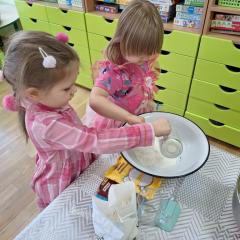 Dziewczynki wsypują mąkę do miski