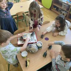 Dzieci bawią się figurkami dinozaurów