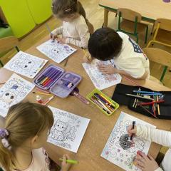 Dzieci kolorują kredkami