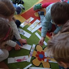 Dzieci układają pocięte obrazki Kubusia Puchatka