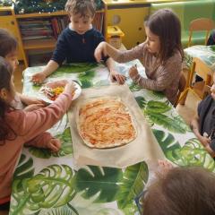 Słonka kładą dodatki na pizzę