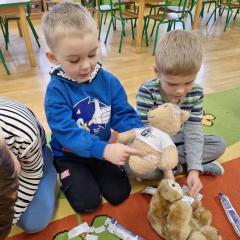 chłopiec pokazuje gdzie przykleił plasterki misiowi