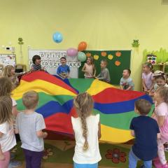 Zabawa chusta animacyjną, dzieci podrzucają balony