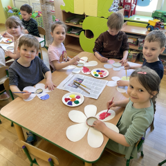 Dzieci przy stolikach wykonują pracę plastyczną