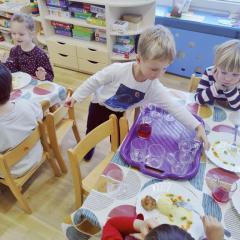 Chłopiec w czasie dyżuru zbiera szklanki