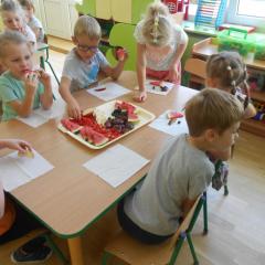 Dzieci wybierają czerwone owoce z tacy