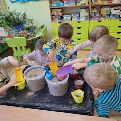 dzieci wsypują piasek do pojemników