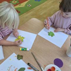 dziewczynki malują farbami liście