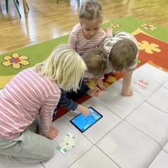 Chłopiec koduje drogę Photona na tablecie, dzieci pomagają mu w dalszych krokach