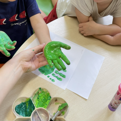 Pomalowana zieloną farbą dłoń dziecka