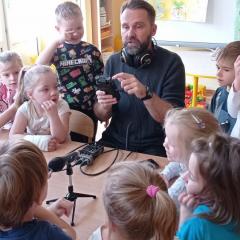 Pan redaktor prezentuje sprzęt potrzebny do pracy