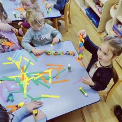 Dzieci wspólnie robią łańcuch choinkowy