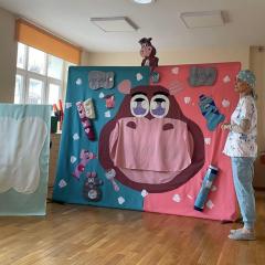 Aktorka w stroju dentystki rozmawia z postacią hipopotama, występującego w przedstawieniu