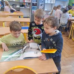 chłopcy oglądają książkę