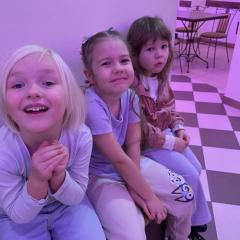 Dzieci siedzą przy stoliku i czekają na spektakl