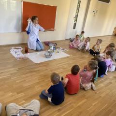 Dzieci zgłaszają się do odpowiedzi na zadane pytanie przez prowadzącą