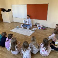 Prowadząca prezentuje ilustracje, dzieci słuchają