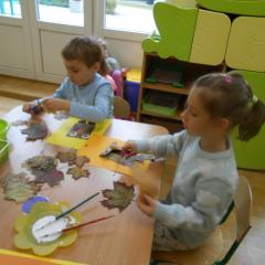 Edzio i Kamilka przyklejają liście do sowy