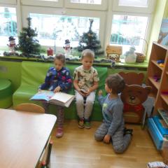Kamila z chłopcami czyta książkę